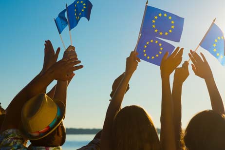 Menschen wehen mit kleinen Europaflaggen