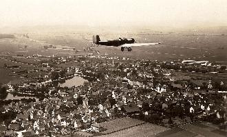 Schwarz-Weiß-Bild Propellerflugzeug über Böblingen