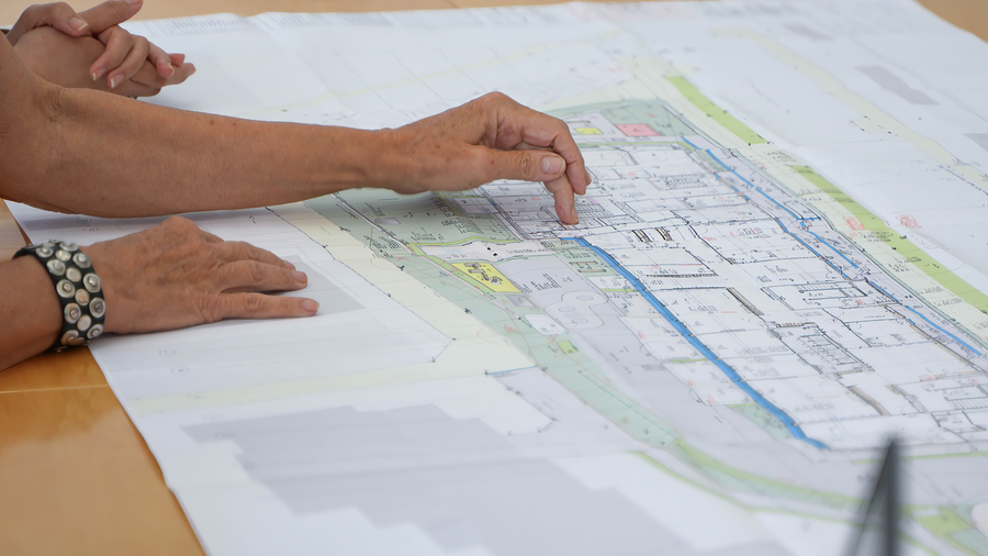 Bauplan auf dem Tisch mit Händen