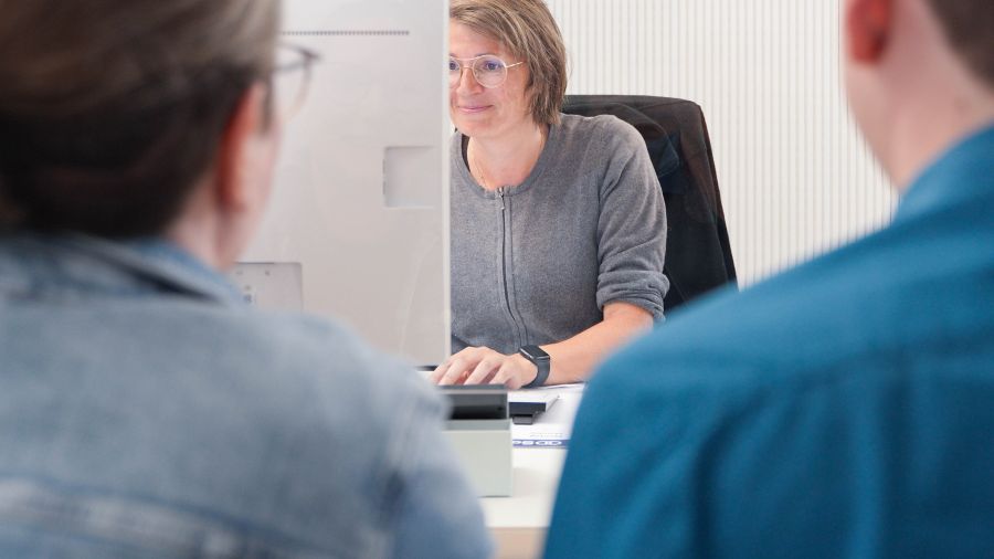 Frau am PC mit 2 Bürgern am Tisch Frau am PC mit 2 Bürgern am Tisch