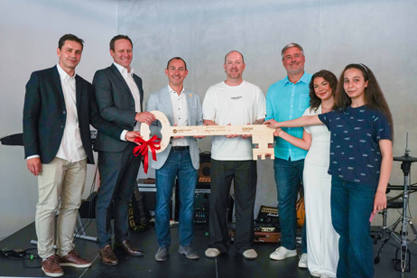 Großer symbolischer Holzschlüssel zur Übergabe des neuen Schulzentrums mit Oberbürgermeister und weiteren Personen